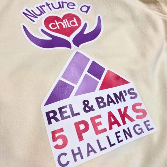 An image of the cream-colored Nurture a Child shirt.